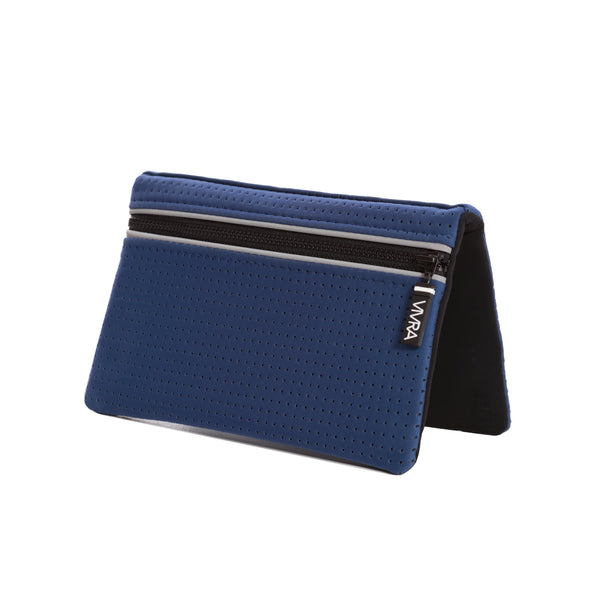 Bi-fold belt-less magnetic bum bag made of neoprene fabric in bold blue block colour. Neoprene has a perforated sporty design aesthetic.  Waist bag contains 4 concealed magnets – one in each corner to secure to any waist band.
