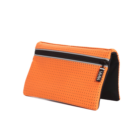 Bi-fold belt-less magnetic bum bag made of neoprene fabric in bright orange block colour. Neoprene has a perforated sporty design aesthetic.  Waist bag contains 4 concealed magnets – one in each corner to secure to any waist band.