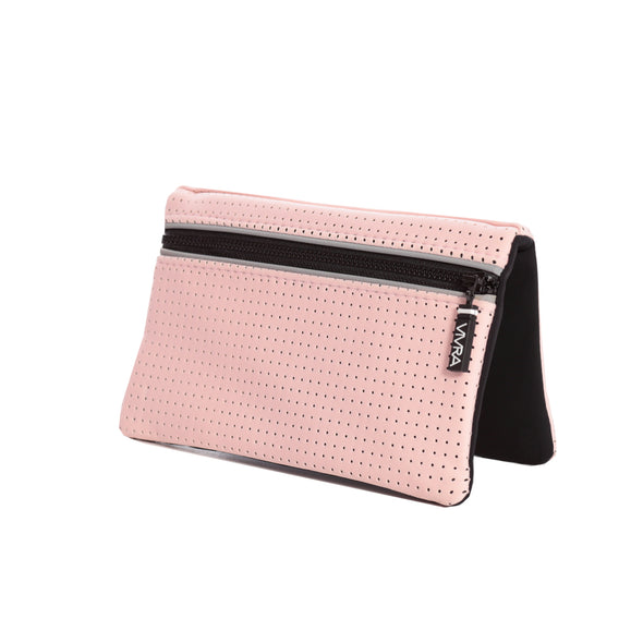 Bi-fold belt-less magnetic bum bag made of neoprene fabric in plain pastel pink block colour. Neoprene has a perforated sporty design aesthetic.  Waist bag contains 4 concealed magnets – one in each corner to secure to any waist band.
