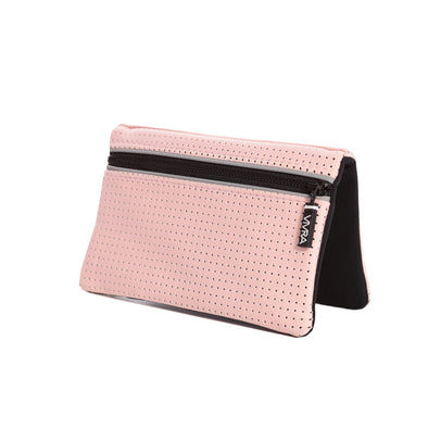 Bi-fold belt-less magnetic bum bag made of neoprene fabric in plain pastel pink block colour. Neoprene has a perforated sporty design aesthetic.  Waist bag contains 4 concealed magnets – one in each corner to secure to any waist band.